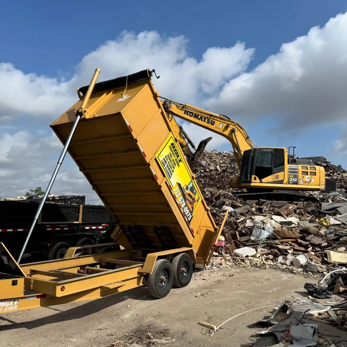 Excavator and dump trailer at a disposal site