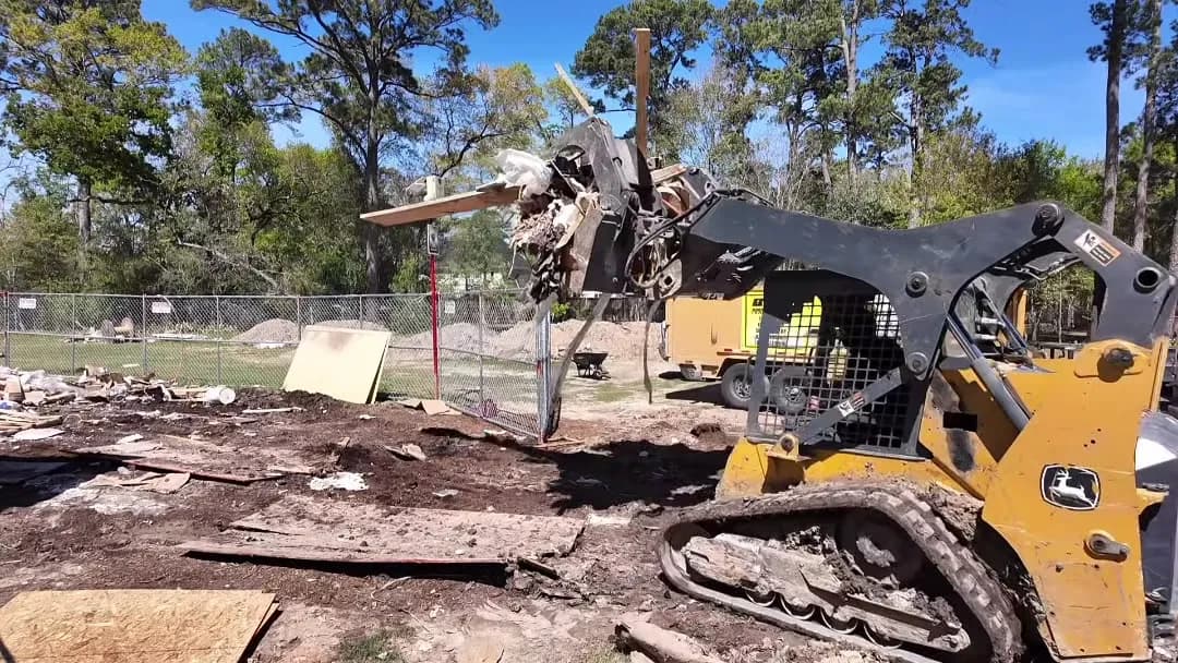 John Deere track loader with a grapple on an active site